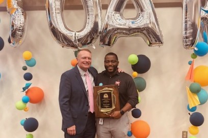 Mr. Glenn holds the Principal of the Year plaque alongside Superintendent Kevin Hendrick